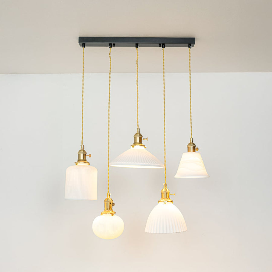 White glass and gold metal pendant lights designed for sophisticated contemporary home decor spaces.