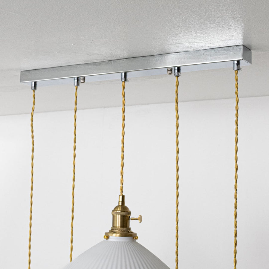 Silver metal linear ceiling canopy with decorative chains highlighting sleek modern craftsmanship.