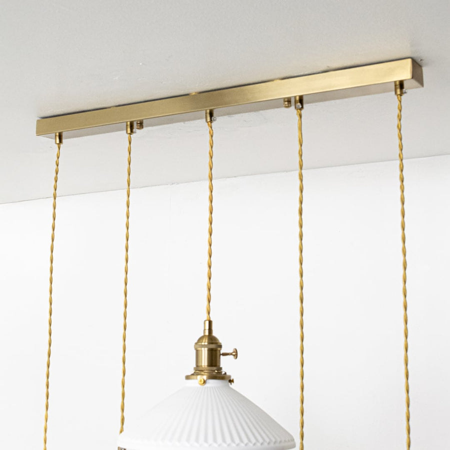 Gold metal linear canopy with decorative chains showcasing premium finish and modern craftsmanship.