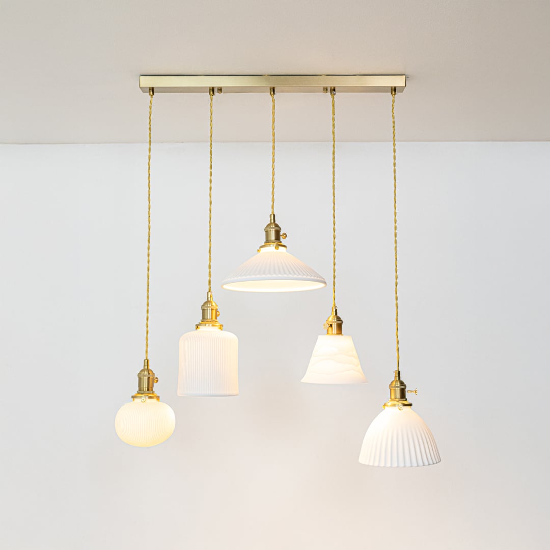 White glass and gold metal pendant lights designed for sophisticated contemporary home decor spaces.