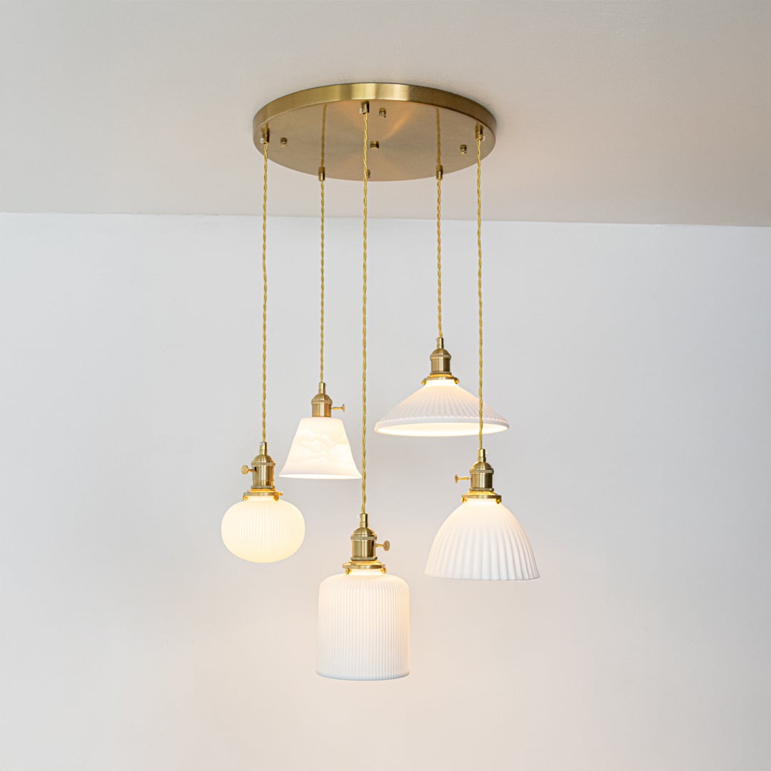 White glass and gold metal pendant lights designed for sophisticated modern home decor spaces.