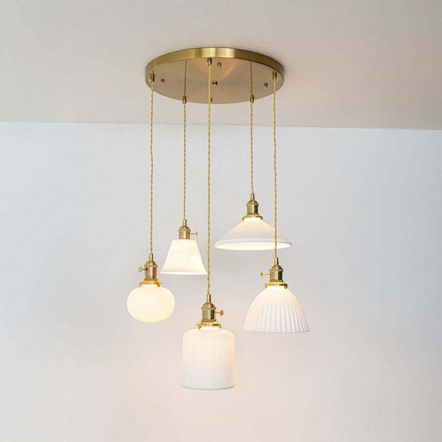 White glass and gold metal pendant lights designed for sophisticated modern home decor spaces.