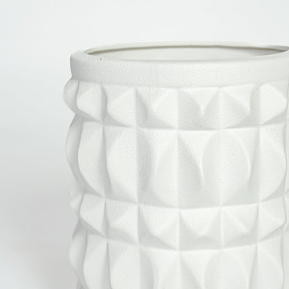 Close view of white ceramic geometric planter highlighting raised textured pattern and smooth matte finish.