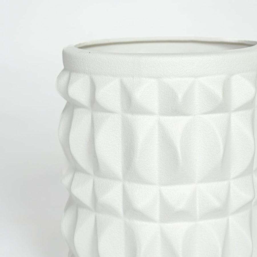 Close view of white ceramic geometric planter highlighting raised textured pattern and smooth matte finish.