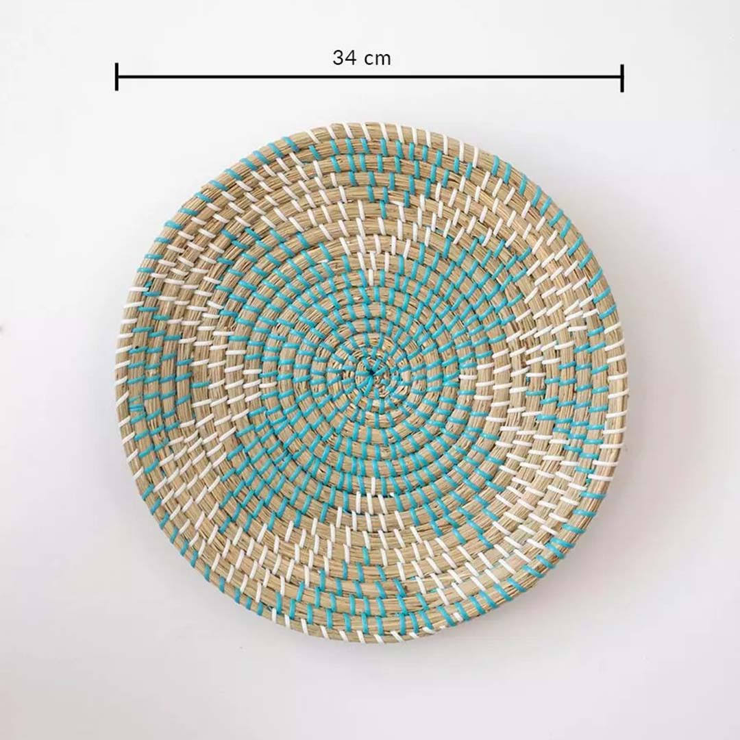Handwoven seagrass round wall basket decor in natural beige and teal with spiral woven pattern and size guide on white.