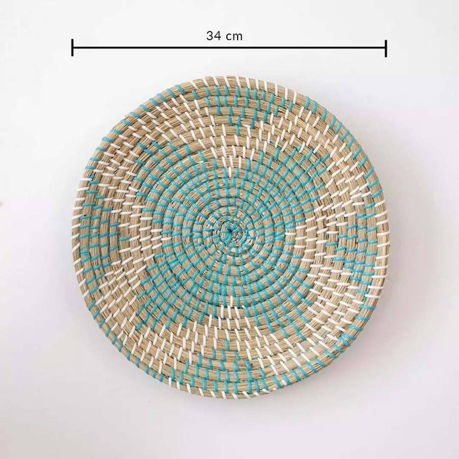 Handwoven seagrass round wall basket decor in natural beige and teal with spiral woven pattern and size guide on white.