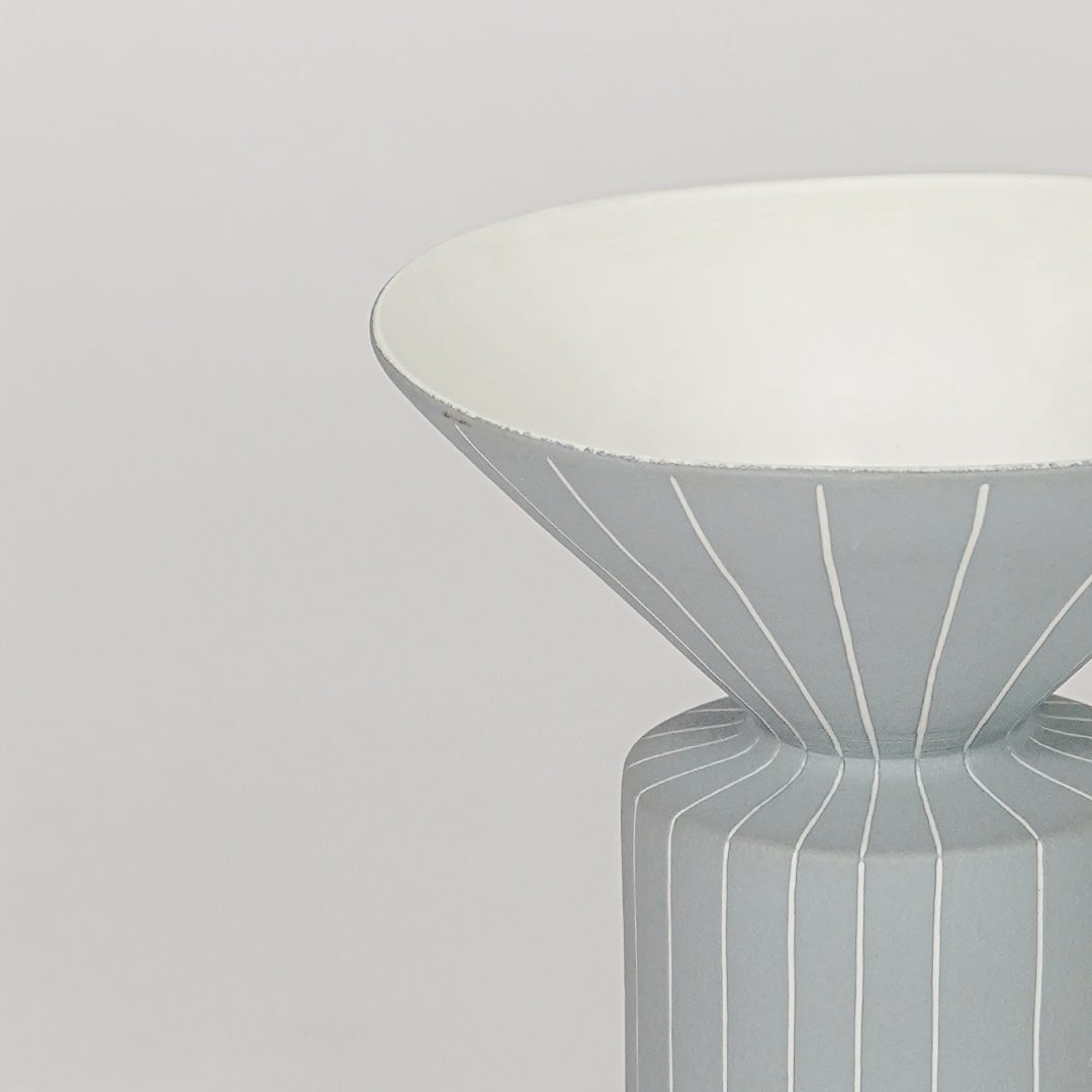 Blue ceramic flower vase closeup with ribbed texture modern decorative vase for shelf console table home decor styling.