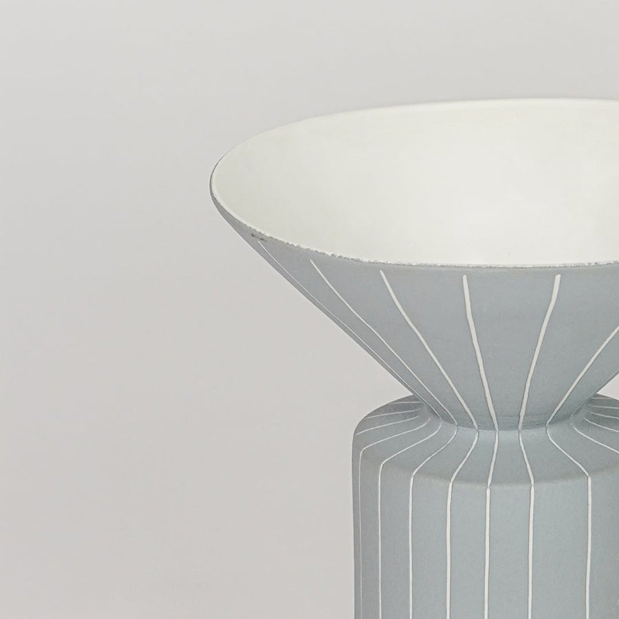 Blue ceramic flower vase closeup with ribbed texture modern decorative vase for shelf console table home decor styling.