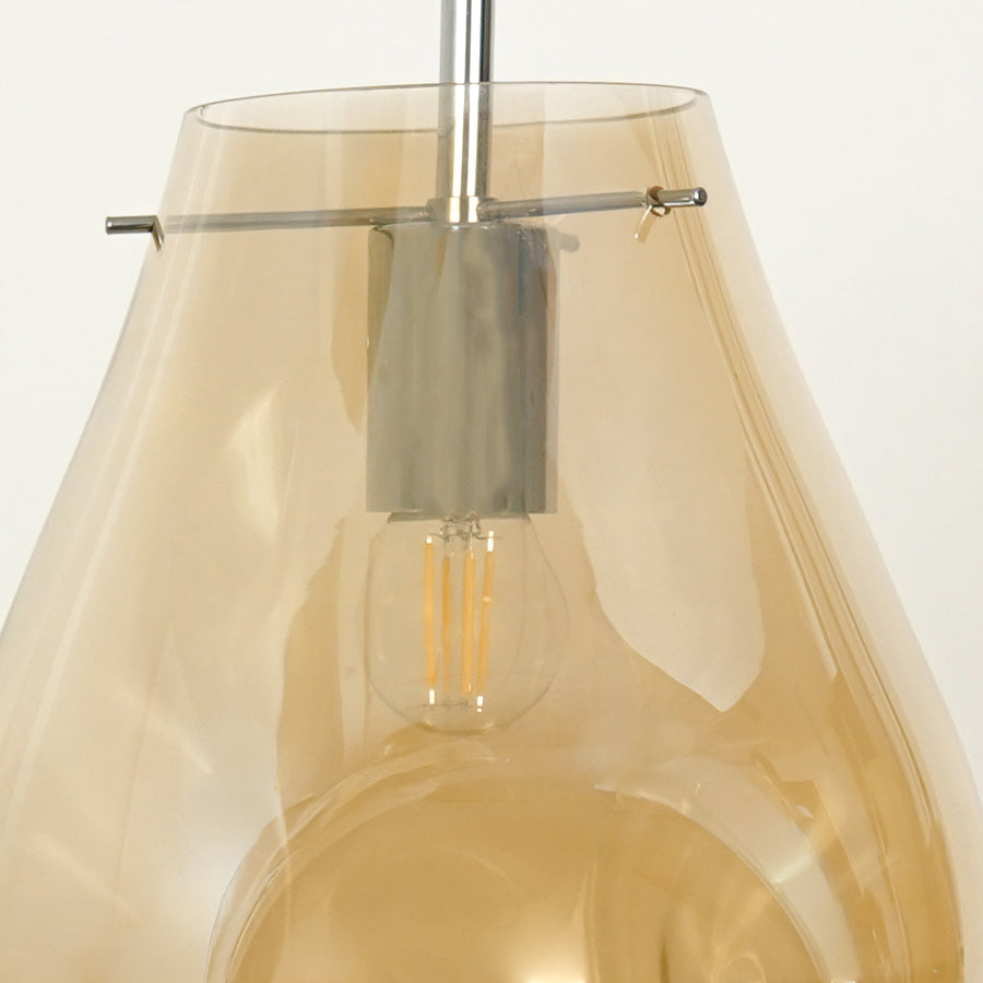Amber glass pendant light closeup showcasing tinted glass shade and sleek metal detailing.