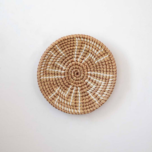 Minimalist handcrafted woven seagrass wall hanging basket decor plate featuring a brown geometric pattern on white.