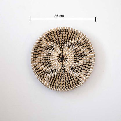 Minimalist handcrafted woven seagrass wall hanging basket decor plate featuring a beige geometric pattern on white.
