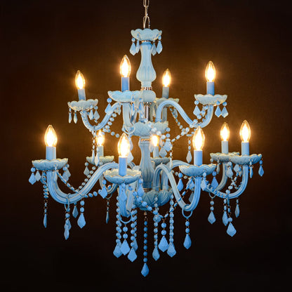 Large blue crystal chandelier glowing warmly on black background creating a striking luxury ceiling feature.