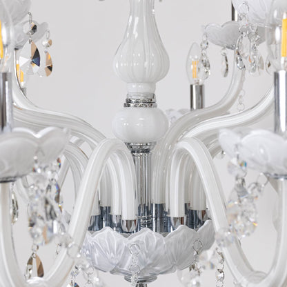 Closeup of white chandelier with crystal droplets and decorative design highlighting luxury lighting details.
