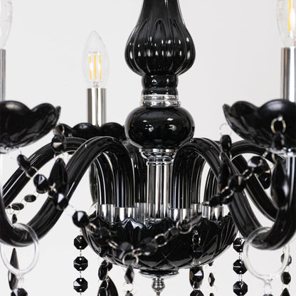 Closeup of black chandelier with crystal detailing and glossy arms showing luxury lighting design features.