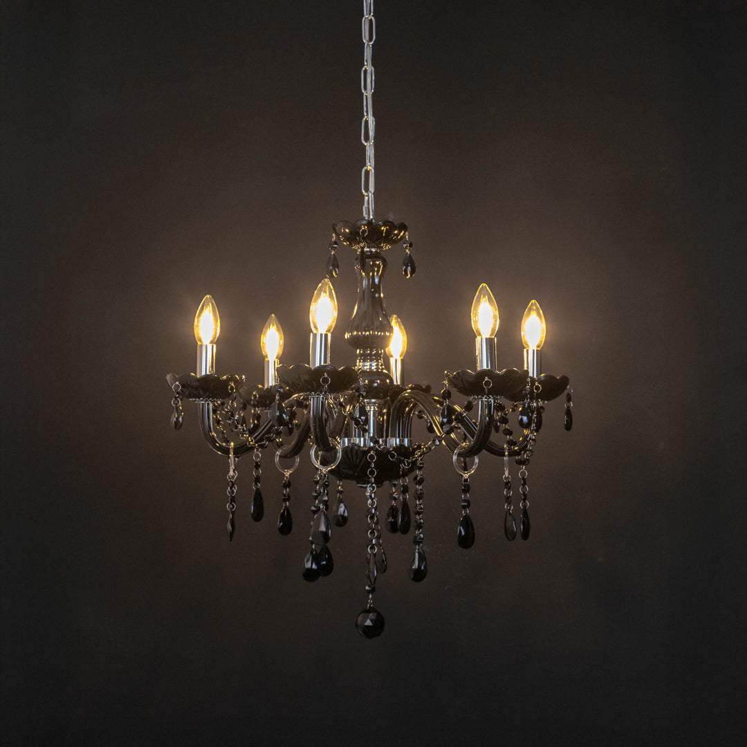 Black crystal chandelier with illuminated candle bulbs and cascading crystal accents creating dramatic luxury ambient lighting.