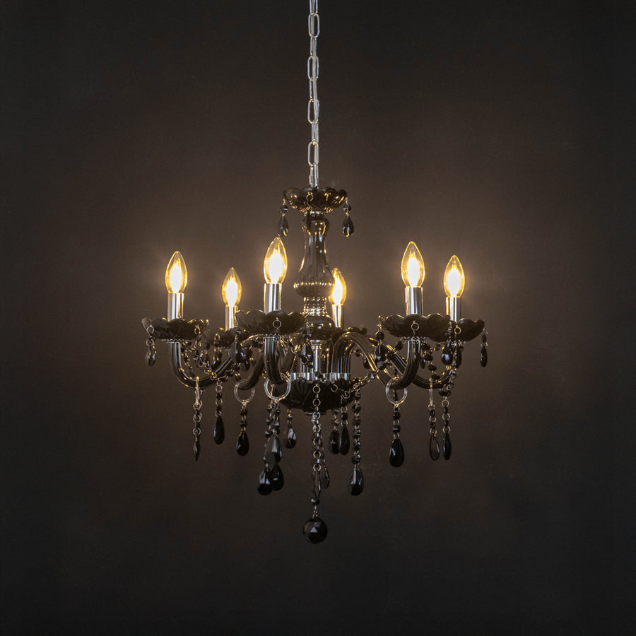Black crystal chandelier with illuminated candle bulbs and cascading crystal accents creating dramatic luxury ambient lighting.