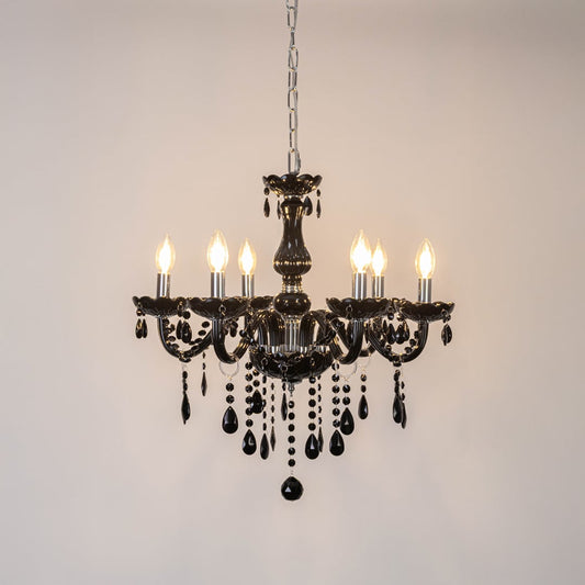 Black chandelier with crystal detailing glowing brightly on white background for elegant luxury interior decor.