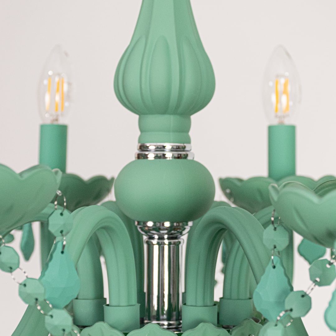 Closeup of green crystal chandelier with detailed beads and curved arms perfect for stylish luxury ceiling lighting.
