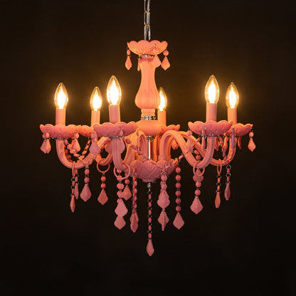 Pink crystal chandelier glowing warmly on black background creating a striking luxury ceiling feature.
