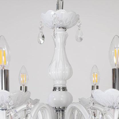 Closeup of white chandelier with crystal accents showing detailed arms and hanging droplets for decor style.