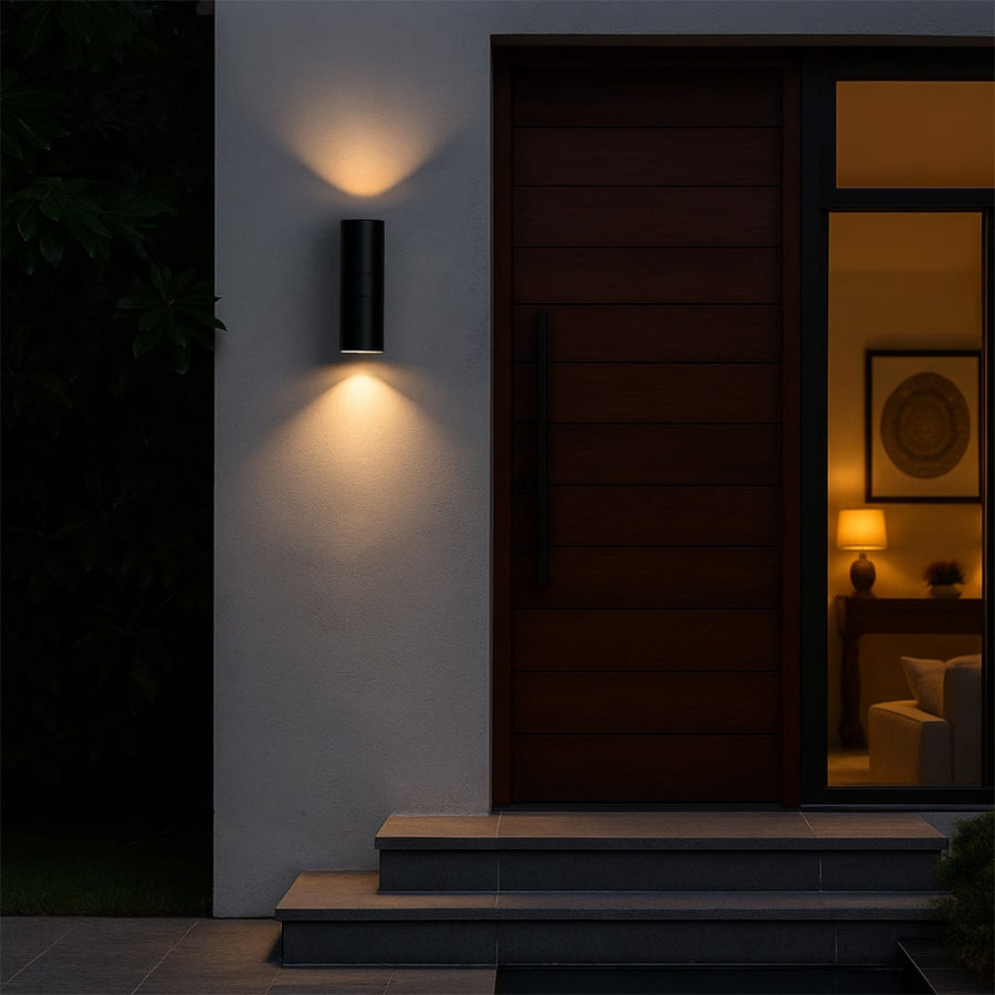 Tall black metal cylindrical outdoor wall light adding modern style to exterior walls for sleek contemporary home decor.