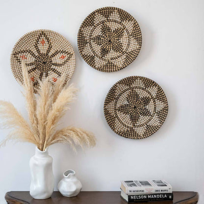 Handwoven seagrass wall basket decor set in natural beige and black displayed above a console table for elegant boho home style.