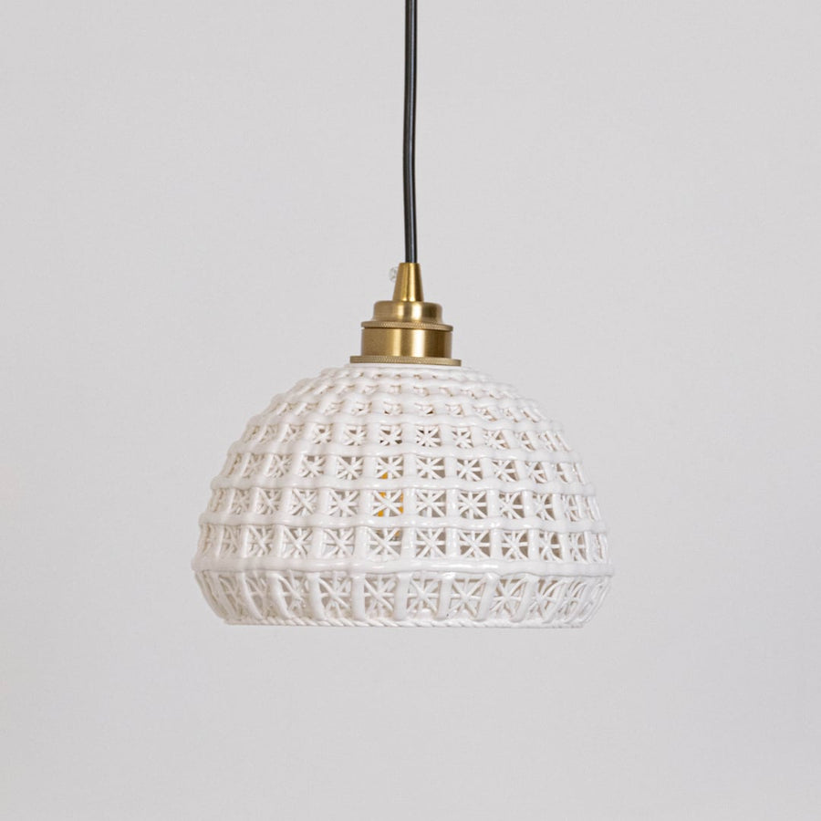 White woven pendant light displayed on a white background with lights off highlighting its woven dome shape.