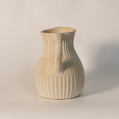 Twin handle vase displayed on a white background highlighting ribbed ceramic detailing and elegant curved design.