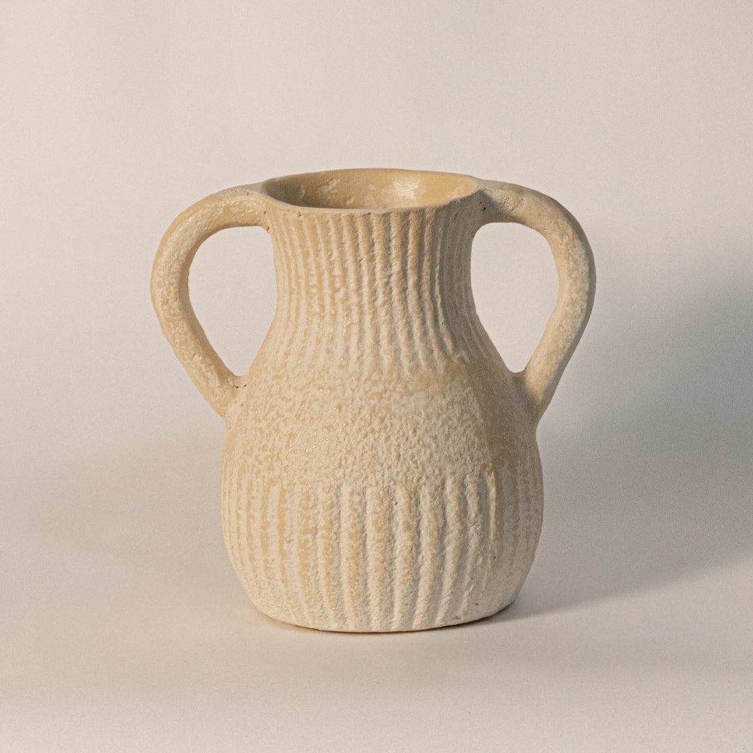Decorative ceramic vase with dual handles in beige finish and ribbed texture for table decor or shelf styling modern home placement white background.