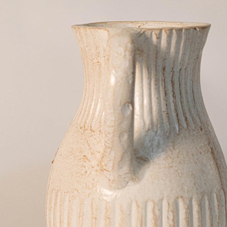 Close-up of double handle vase showing ribbed ceramic texture and handmade detailing for an artisanal finish.
