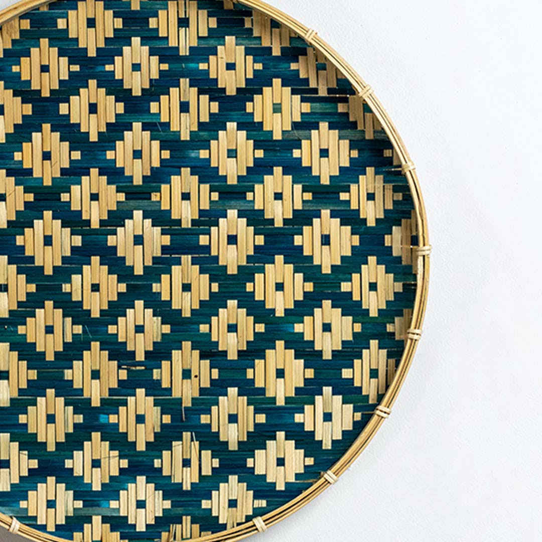 Closeup of handcrafted blue and natural seagrass wall basket with geometric woven pattern for artisan home décor.