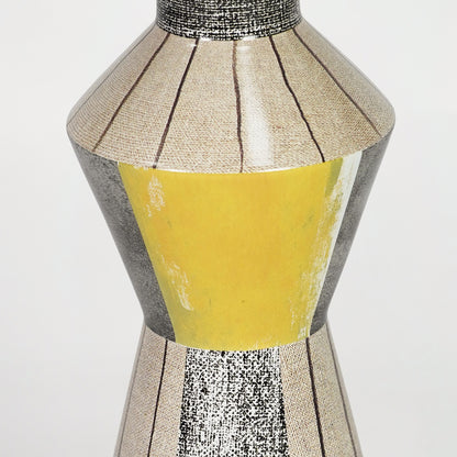 Closeup image of yellow glass table lamp with metallic detailing for luxury bedside decor styling and elegance.