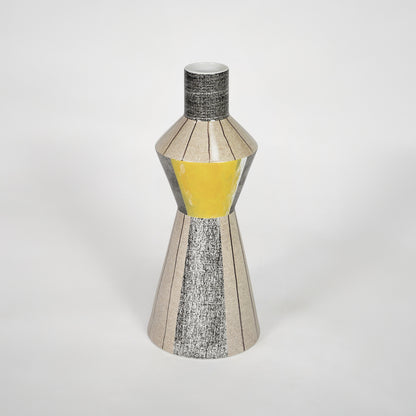 Modern silver decorative vase with yellow glass detail for stylish shelf placement and contemporary home decor styling.