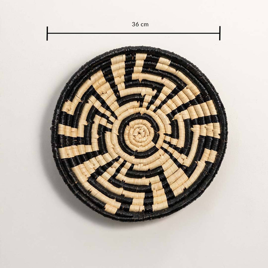 Dimension image of handcrafted black cream seagrass wall basket with geometric sunburst labyrinth pattern for boho decor.