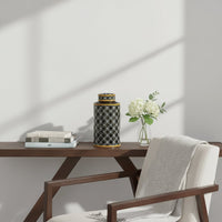 Black ceramic decorative storage jar styled on a wooden table for elegant contemporary home decor settings.