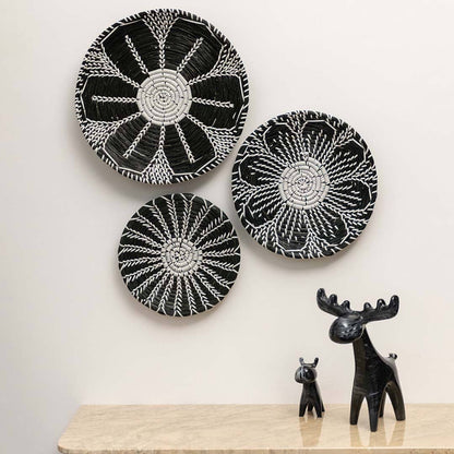 Handcrafted black white seagrass wall basket set with abstract floral leaf patterns in lifestyle boho living room decor.