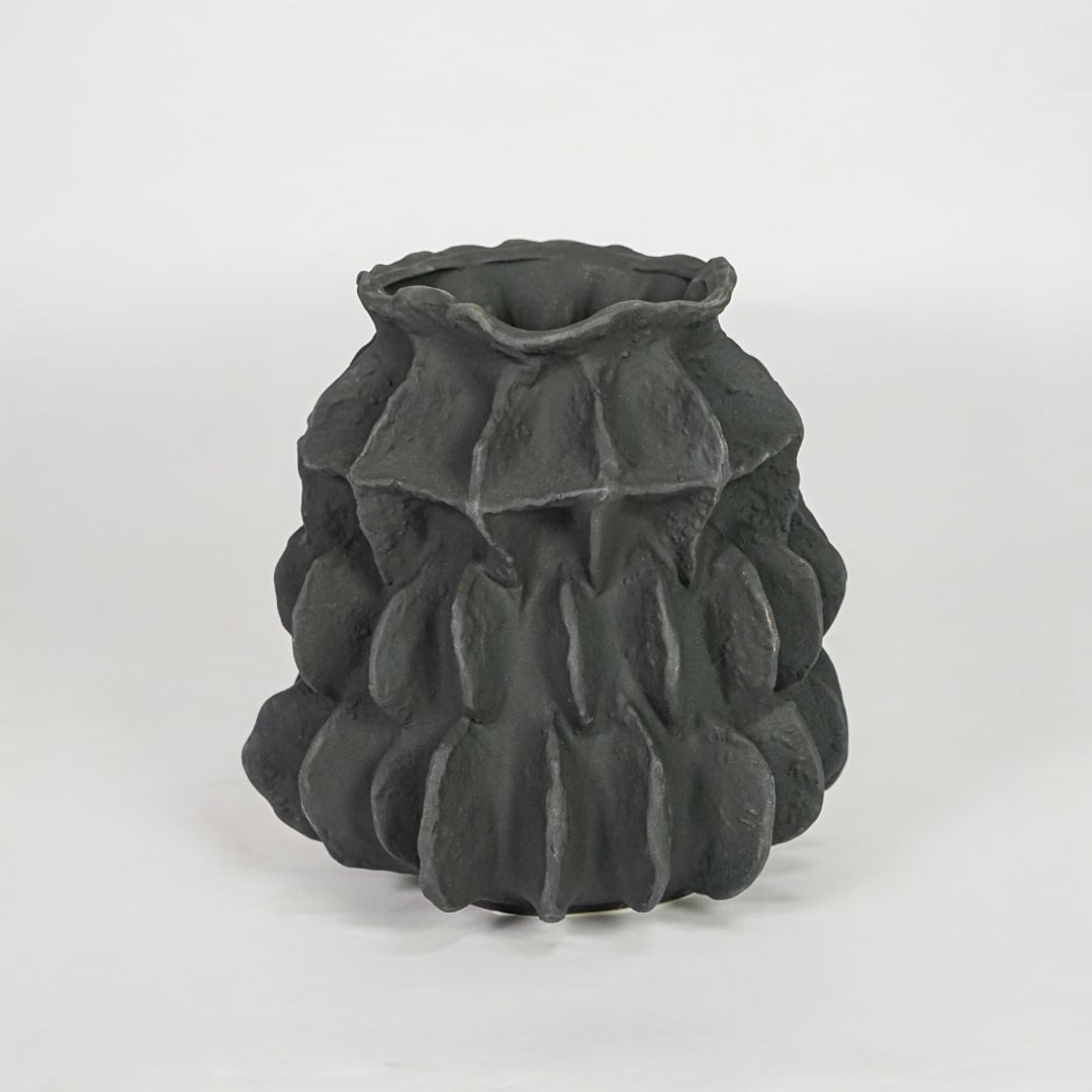 black textured round ceramic vase white background