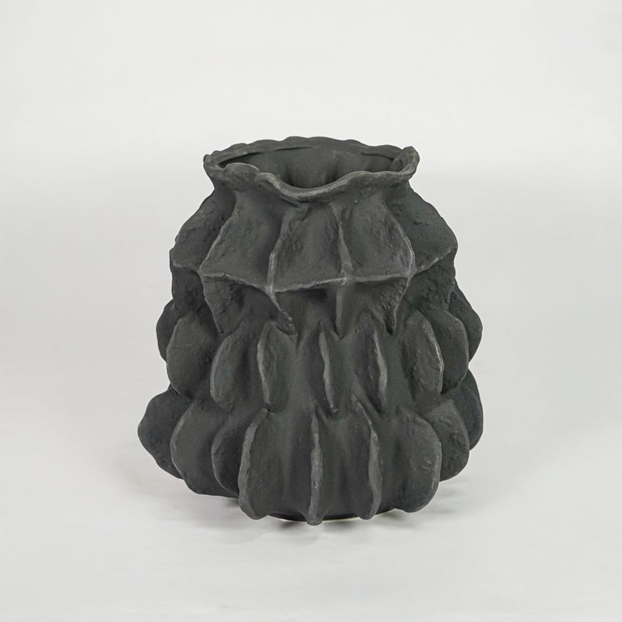 black textured round ceramic vase white background
