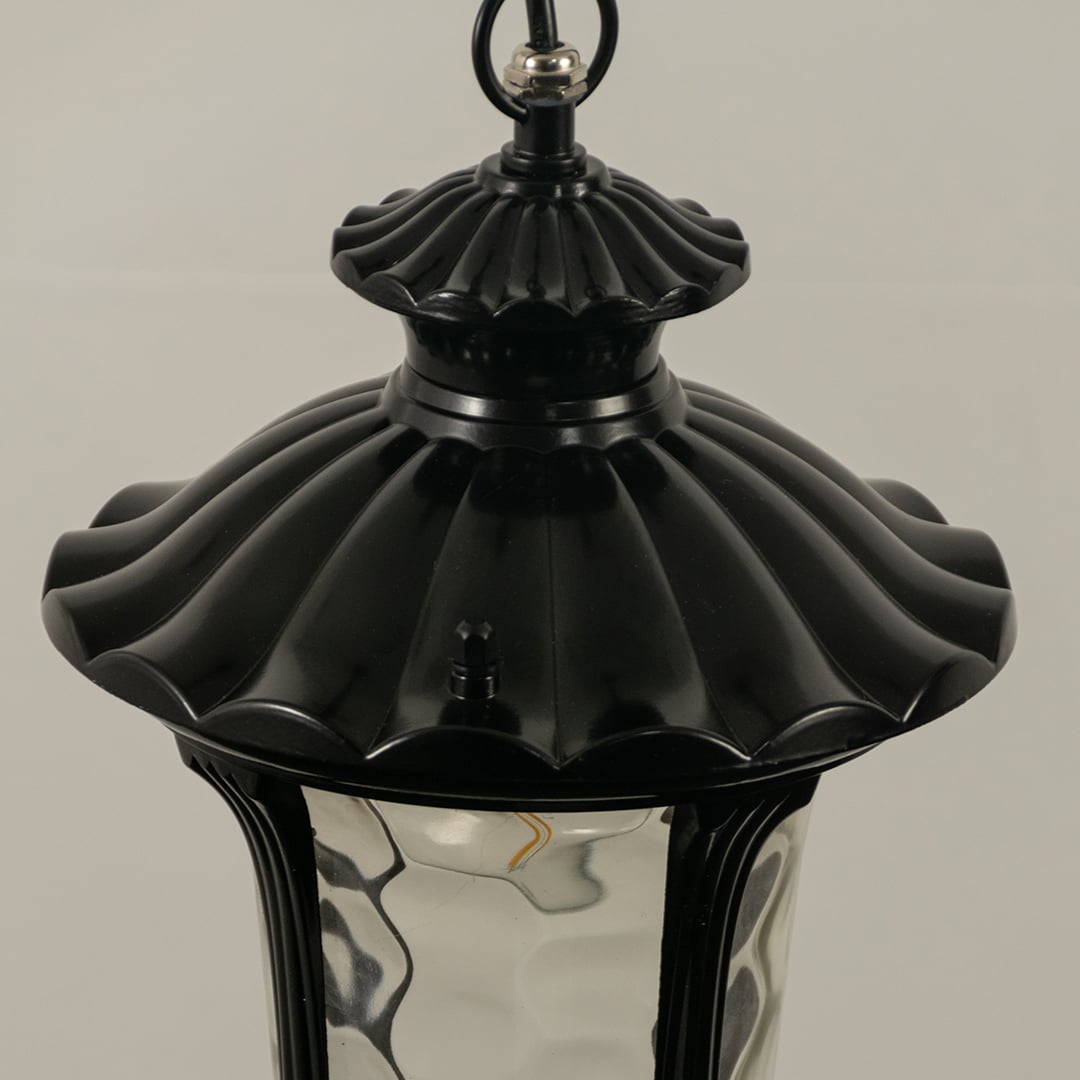 Detailed closeup of black metal lantern highlighting elegant curves and ribbed glass ideal for outdoor walkway balcony and patio lighting Decor.