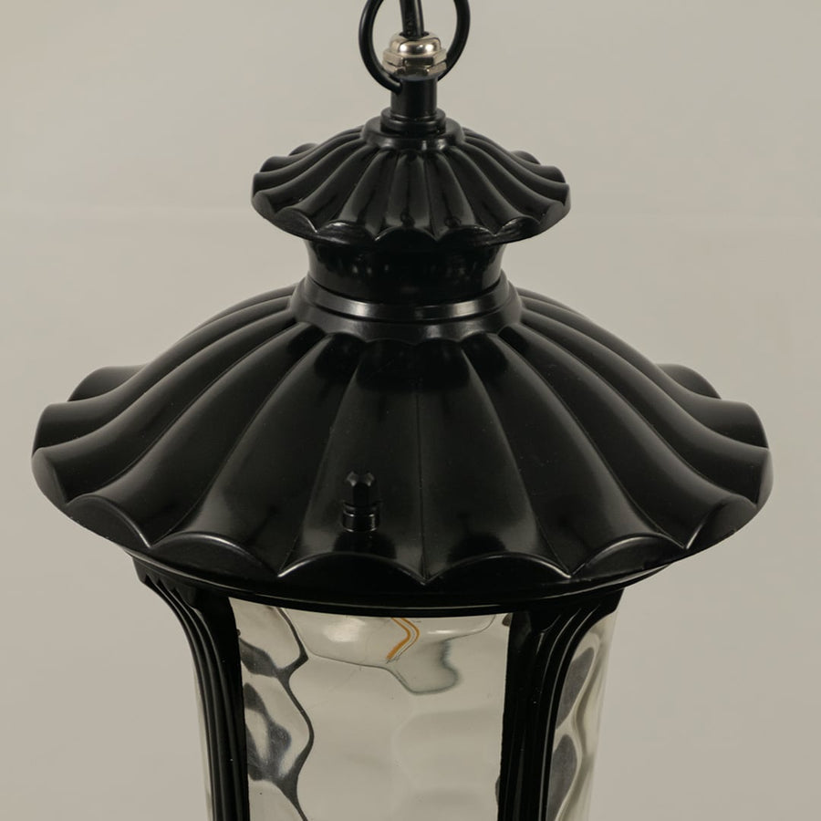 Detailed closeup of black metal lantern highlighting elegant curves and ribbed glass ideal for outdoor walkway balcony and patio lighting Decor.