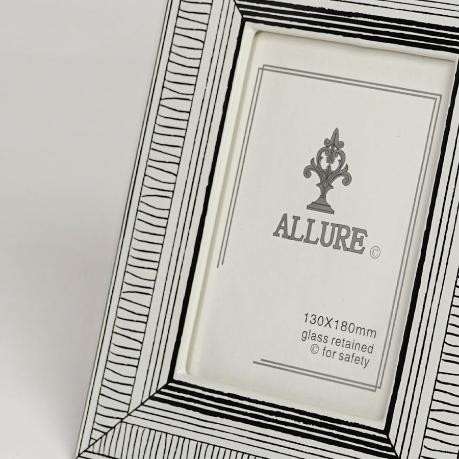 Close up view of silver metal photo frame featuring engraved border detailing and classic elegant finish.