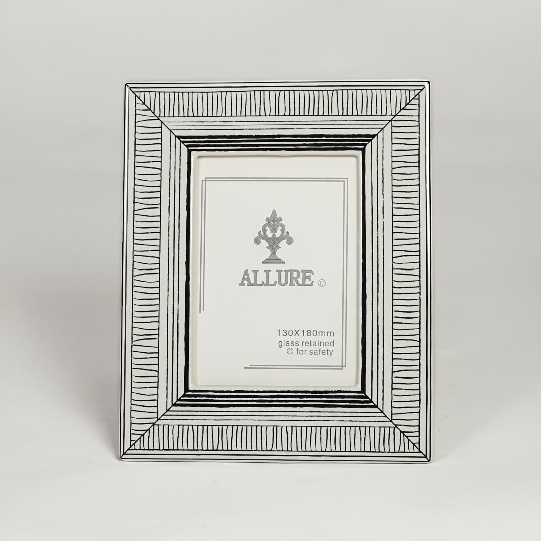 Silver metal photo frame with detailed patterned border isolated on clean white background for elegant tabletop display.