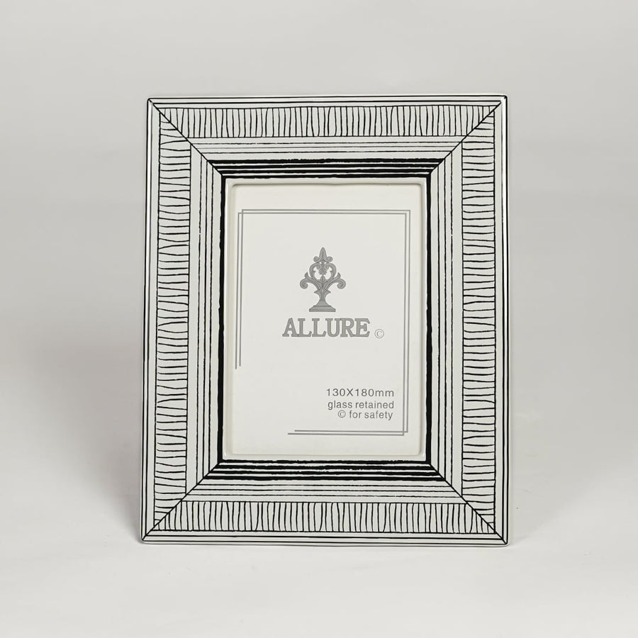 Silver metal photo frame with detailed patterned border isolated on clean white background for elegant tabletop display.