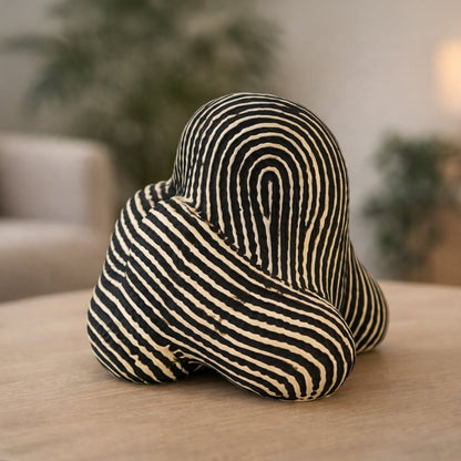 Black and white striped abstract ceramic decor sculpture styled in modern interior artistic tabletop accent for living room shelf console or office decor.