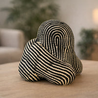 Black and white striped abstract ceramic decor sculpture styled in modern interior artistic tabletop accent for living room shelf console or office decor.