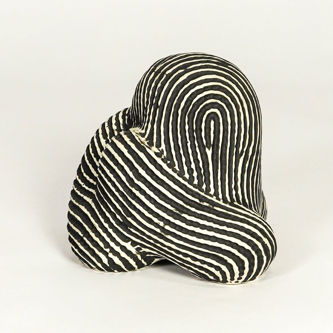 Abstract striped ceramic decor piece on white background modern artistic tabletop accent for living room office or entryway decor.