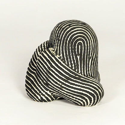 Abstract striped ceramic decor piece on white background modern artistic tabletop accent for living room office or entryway decor.