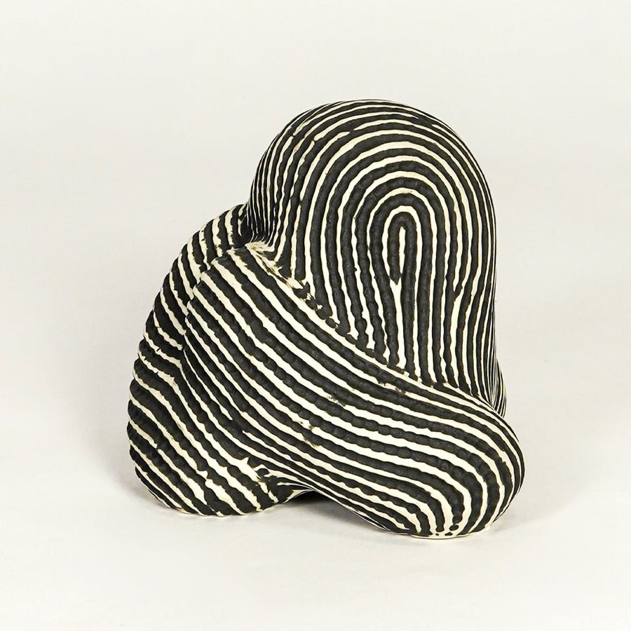 Abstract striped ceramic decor piece on white background modern artistic tabletop accent for living room office or entryway decor.