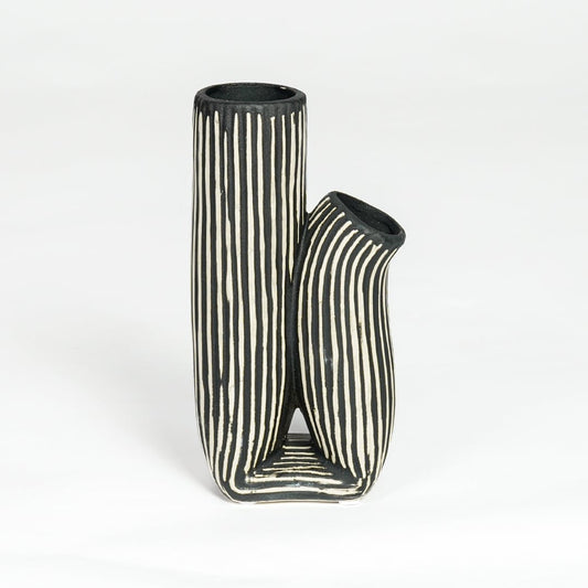 Black and white striped curvy ceramic vase isolated on white background for stylish interior decor placement.