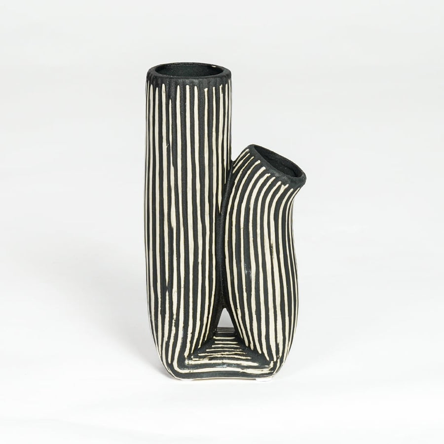 Black and white striped curvy ceramic vase isolated on white background for stylish interior decor placement.